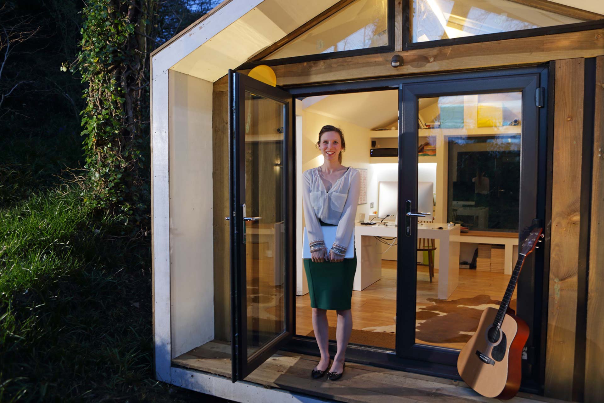 Homeoffice im Gartenhaus - Umbau oder Neubau Frau vor Tiny House - Gartenhaus als Homeoffice